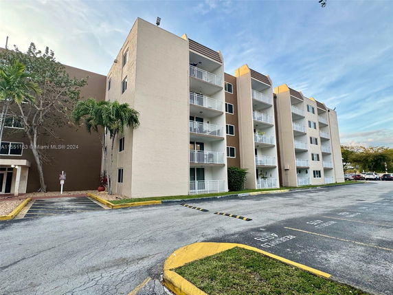 Front view of a multi-story apartment building with balconies.