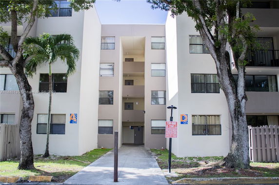Front view of a multi-story apartment building with a central entrance.