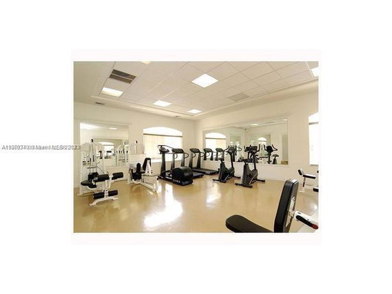 Interior view of a gym with exercise equipment such as treadmills, stationary bikes, and weight machines.