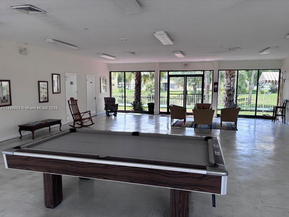 Interior of a recreational room with a pool table and seating area.