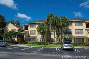 Front view of a multi-story residential building with parking spaces in front.