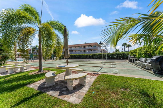 Outdoor area with seating and a court near a building.