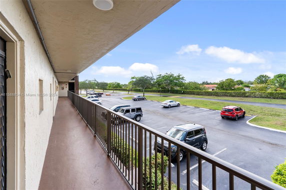View of a parking area adjacent to a building with multiple parked vehicles.