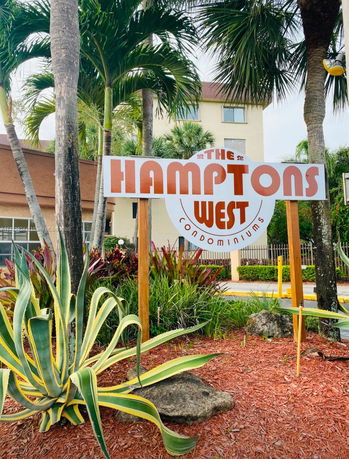Front view of a condominium building with a sign reading 'The Hamptons West'.
