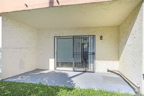 Front view of a building with a sliding glass door and security bars.
