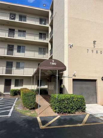 Front view of a multi-story building with balconies and an entrance canopy.