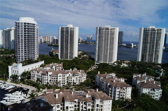 View of tall residential buildings with waterfront in the background.