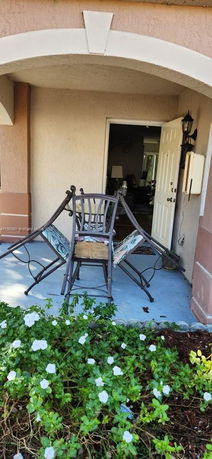 Front view of a house with a small porch and open door.