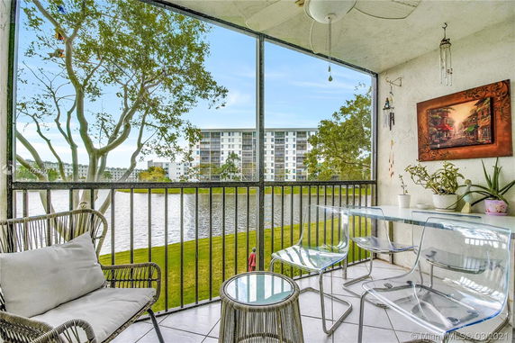 View from a balcony overlooking a lake and an apartment building in the distance.