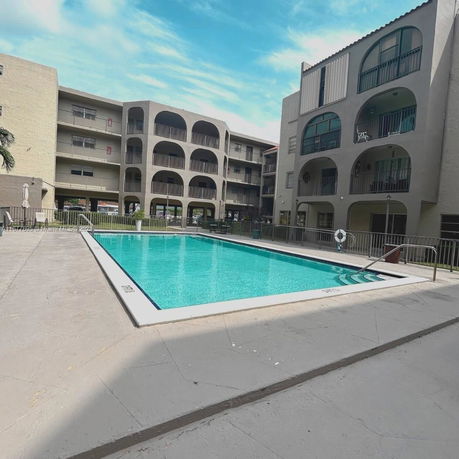 Swimming pool area surrounded by multi-story residential buildings.