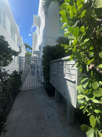 Side view of buildings with mailboxes and a gated pathway.