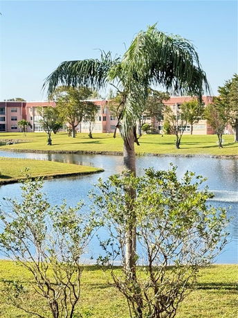 View of surrounding areas with apartment buildings, trees, and a water body.