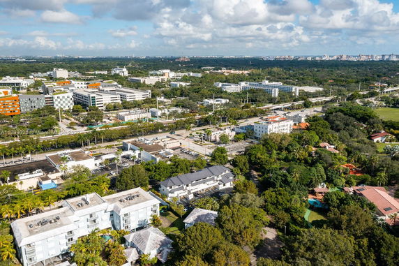 Aerial panoramic view of a cityscape with multiple buildings and green spaces.