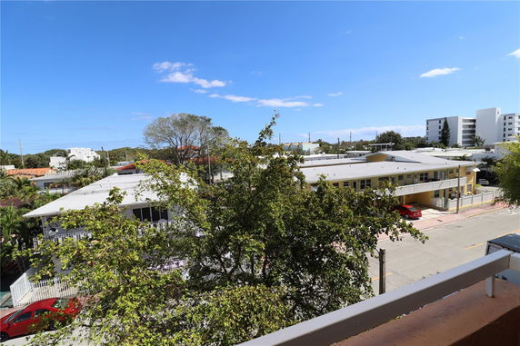 View from a building showing neighboring structures and trees.