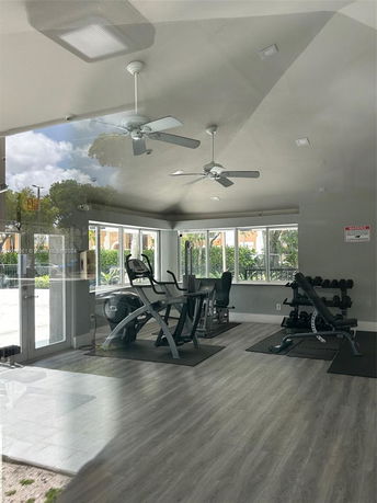 Indoor gym area with exercise equipment and dumbbells.