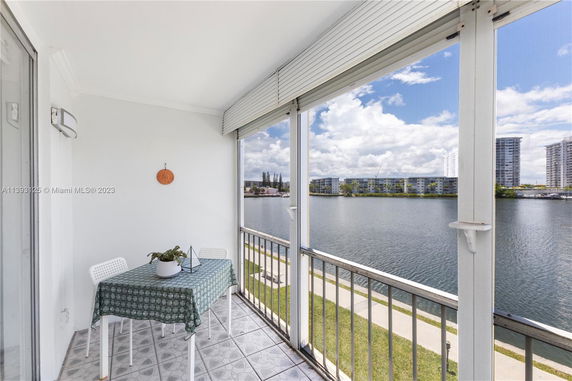 Balcony view overlooking a waterbody with buildings in the background.