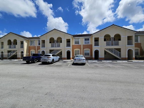 Front view of a two-story apartment building with arched balconies.