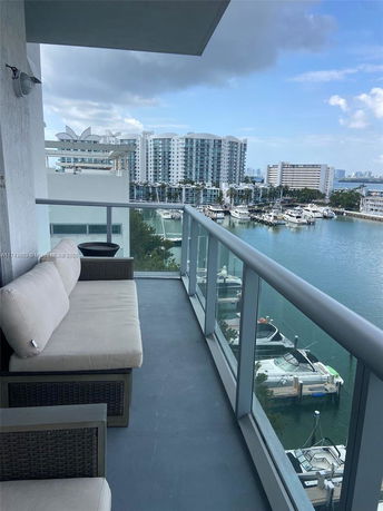 Balcony view overlooking a waterfront with buildings and boats.