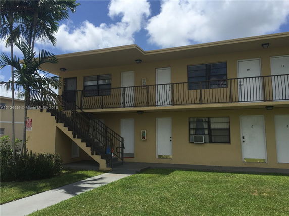Front view of a two-story apartment building with external staircase.
