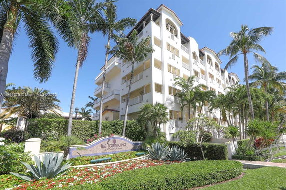 Front view of a multi-story condominium building with balconies and white exterior.