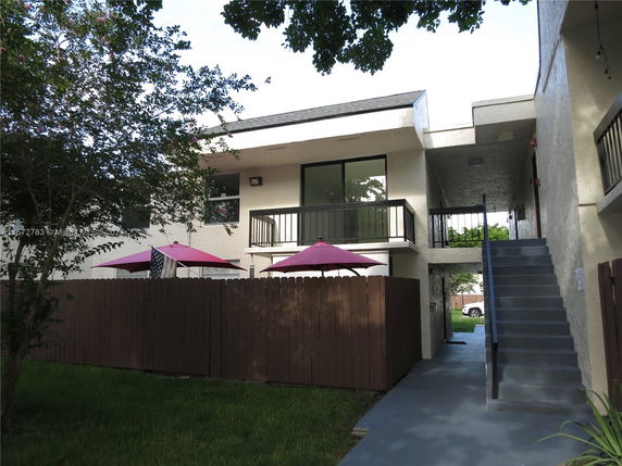 Front view of a multi-story building with exterior stairs and balconies.