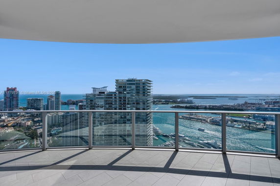 Panoramic view from a balcony overlooking a cityscape and waterway.