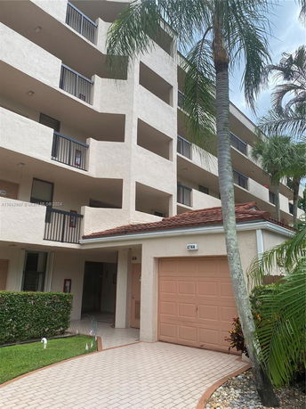 Front view of a multi-story residential building with balconies and a garage.
