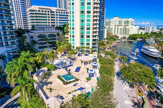 Aerial view of a residential high-rise building near a waterway with boats.