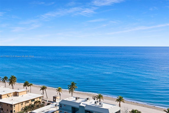 Wide angle view of the ocean with buildings and beach in the foreground.