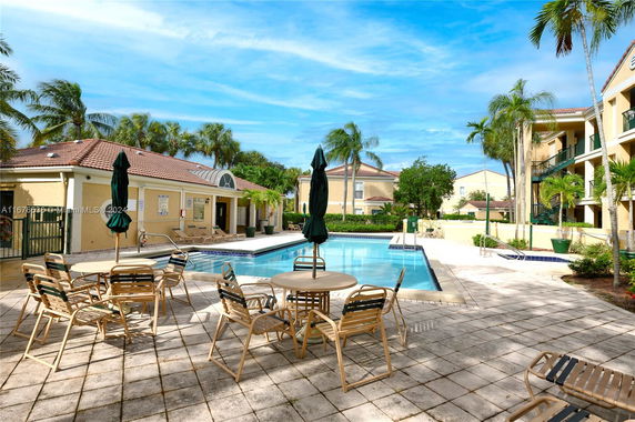 Outdoor swimming pool area with lounge chairs and umbrellas.