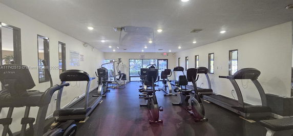 Indoor gym area with exercise machines like treadmills and stationary bikes.