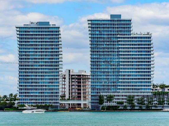 Front view of two modern high-rise buildings by the waterfront.