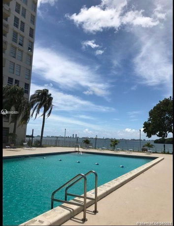 Building exterior with a swimming pool and view of the waterfront.