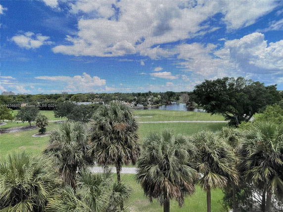Scenic view of trees and a lake under a partly cloudy sky.
