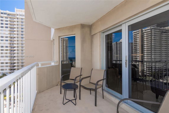 Balcony view from an apartment with reflections of high-rise buildings.
