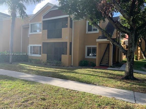 Front view of a two-story residential building with a staircase and screened porch.