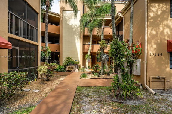 Front view of a multi-story residential building with balconies and landscaping.