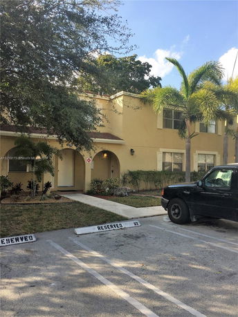 Front view of a two-story house with reserved parking spaces in front.