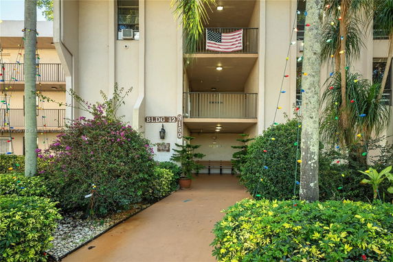 Front view of a multi-story building entrance with balconies and American flag.