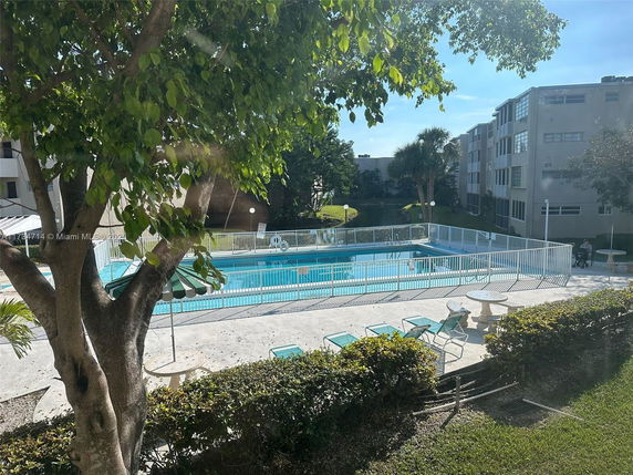 Outdoor swimming pool area surrounded by buildings and greenery