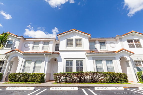 Front view of a two-story house with a tiled roof and two windows on the upper level.