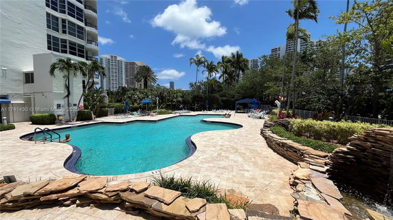 Outdoor swimming pool area with surrounding tall buildings.