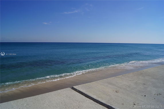 Wide-angle view of a coastline with clear blue sea and sky.