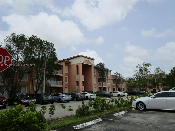 Apartment complex with a parking area in front.