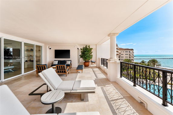Balcony area with outdoor seating and view of the ocean