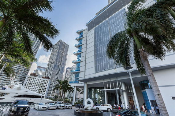 Front view of a modern high-rise building with a glass facade and an entrance area.
