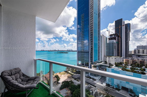 Panoramic view of high-rise buildings and waterfront from a balcony.