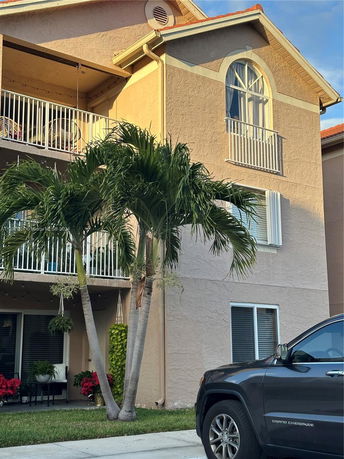 Front view of a multi-story house with balconies and arched windows.