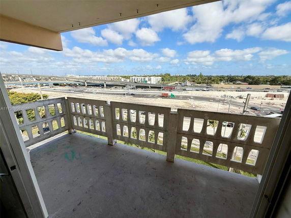 Balcony view overlooking a highway and urban landscape.