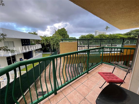 View from a balcony showing nearby buildings and greenery.